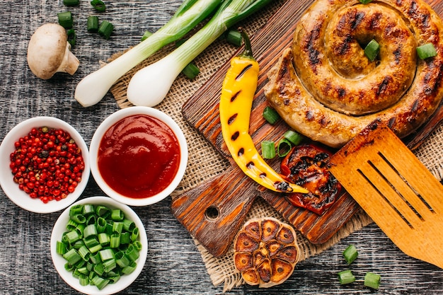 Verdura fresca con salsiccia di lumaca alla griglia sul tavolo