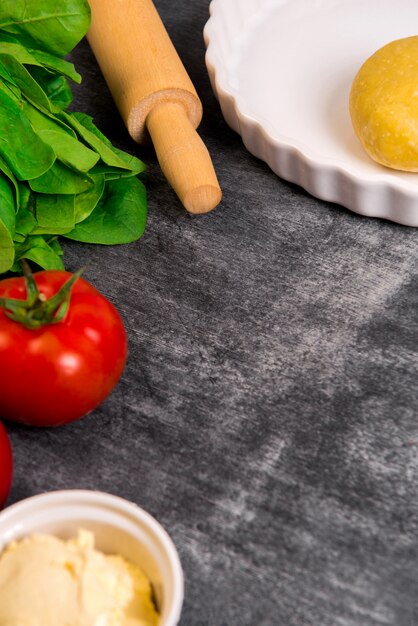 Verdure e pasta sulla superficie in legno grigio