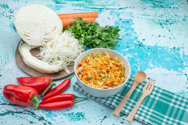 verdure fresche a fette insalata a pezzi lungo e sottile all'interno del piatto con peperoni verdi cavolo su blu