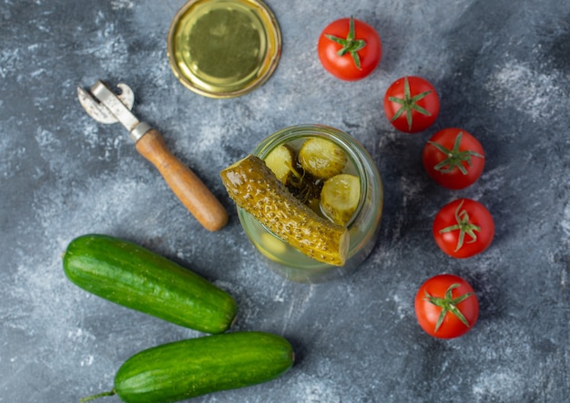 Verdure fresche e in salamoia. Barattolo di sottaceti aperto con pomodoro fresco e cetriolo