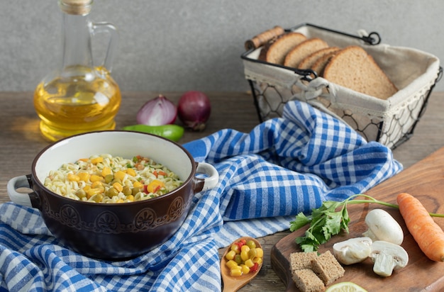 Verdure fresche, pane, olio e tagliatelle sulla tavola di legno