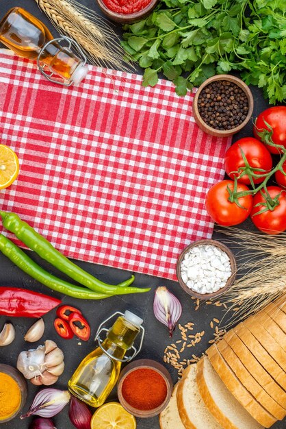 Verdure fresche vista dall'alto con pane verde e condimenti su superficie scura