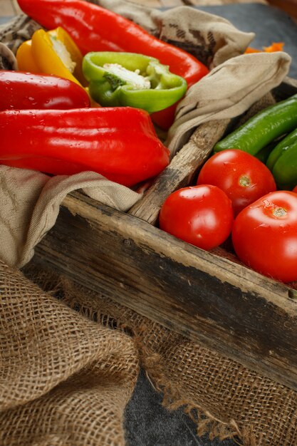 Verdure rosse e verdi in un contenitore di legno.