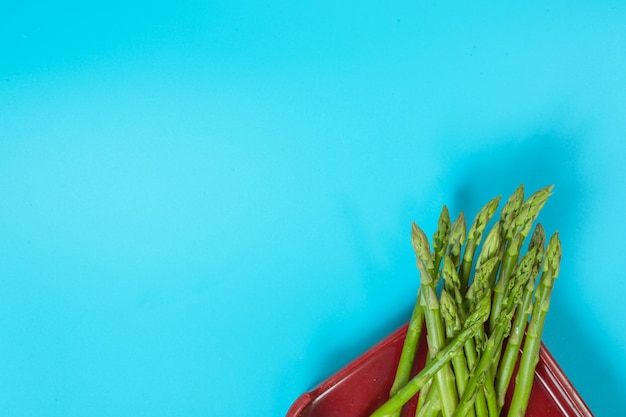 Verdure verdi disposte in un vassoio con colore blu.