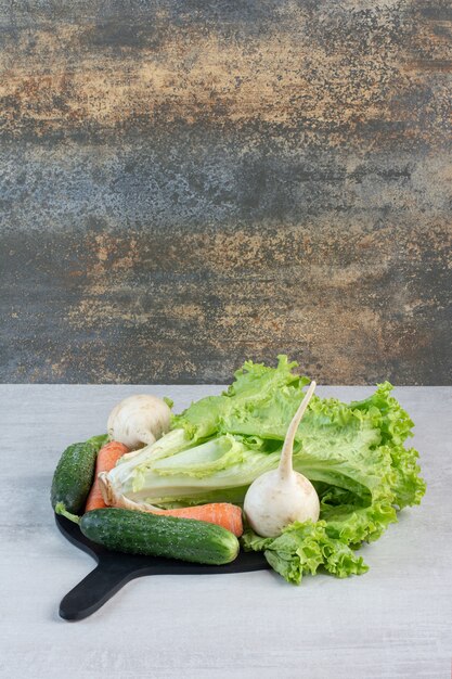 Verdure verdi fresche e carote sul bordo nero. Foto di alta qualità