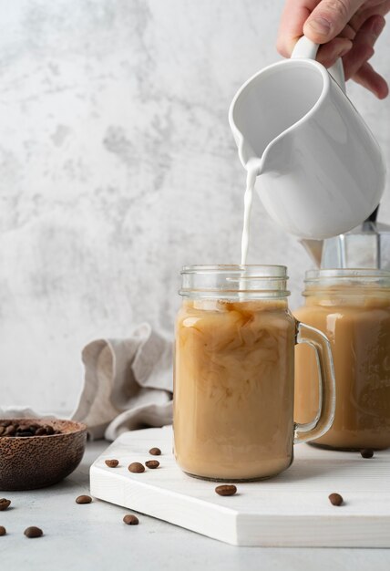 Versare il caffè in tazza da vicino