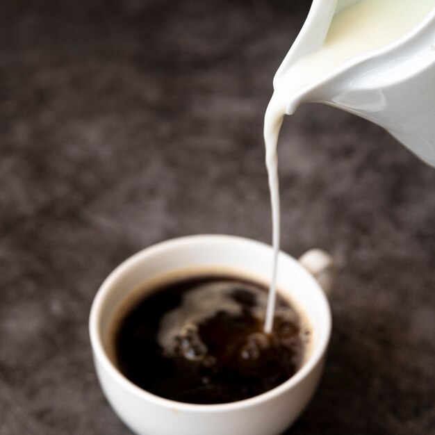 Versare il latte nella tazza di caffè