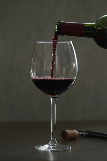 Versare il vino rosso in vetro