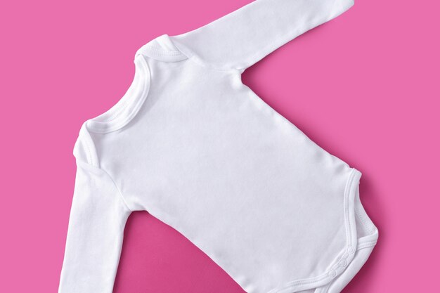 Vestiti bianchi per bambini su sfondo rosa Spazio di copia