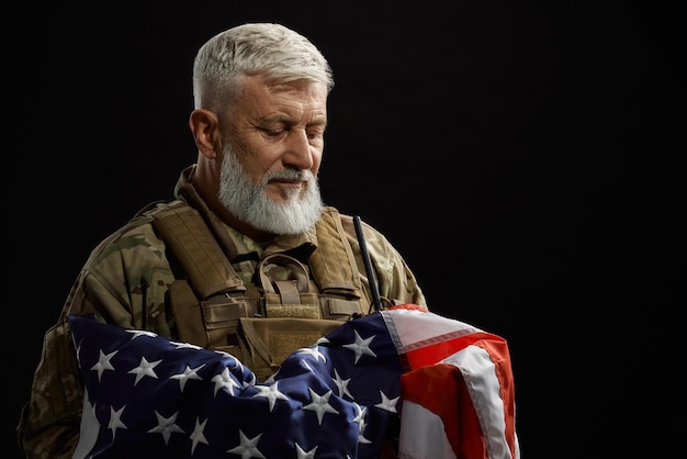 Veterano militare che tiene bandiera americana