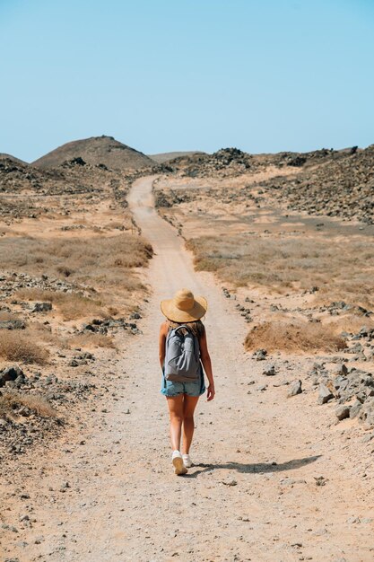 Viaggiatore che cammina lungo la strada di montagna