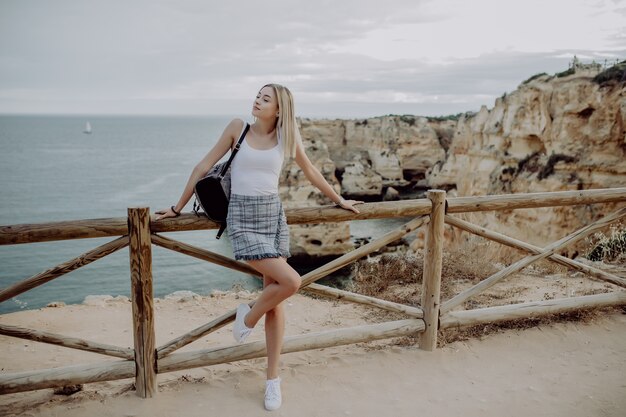 Viaggiatore di hipster giovane bella donna guardando il tramonto e bella vista sul mare con un punto panoramico.