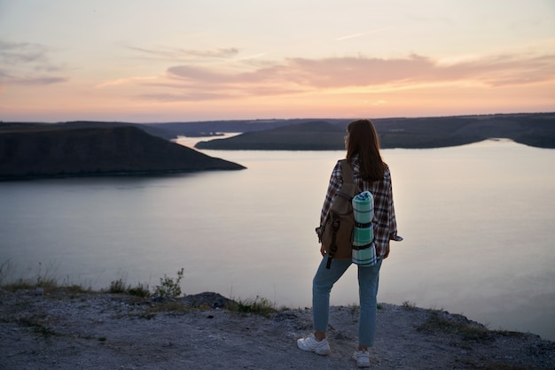 Viaggiatore femminile con zaino in piedi sulla collina a bakota bay