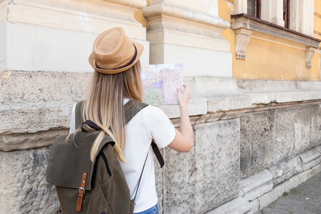 Viaggiatore guardando la mappa da dietro