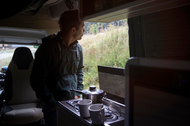 Viaggiatore maschio che fa il suo caffè in un furgone