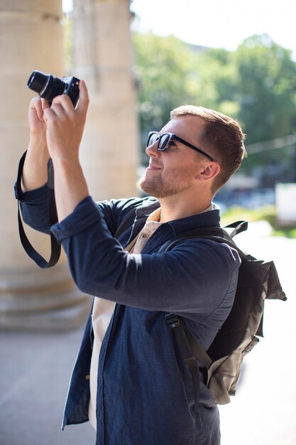 Viaggiatore maschio con una macchina fotografica all'aperto