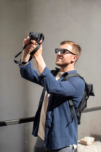 Viaggiatore maschio con una macchina fotografica in un luogo locale