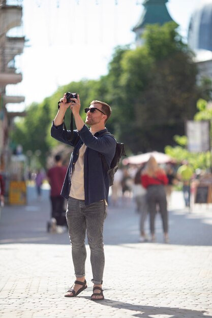 Viaggiatore maschio con una macchina fotografica in un parco locale