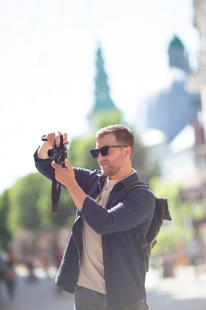 Viaggiatore maschio con una macchina fotografica in un parco locale