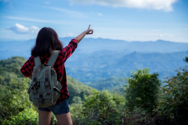 Viaggiatori, giovani donne, guardano le meravigliose montagne e foreste, idee di viaggio per la voglia di viaggiare,