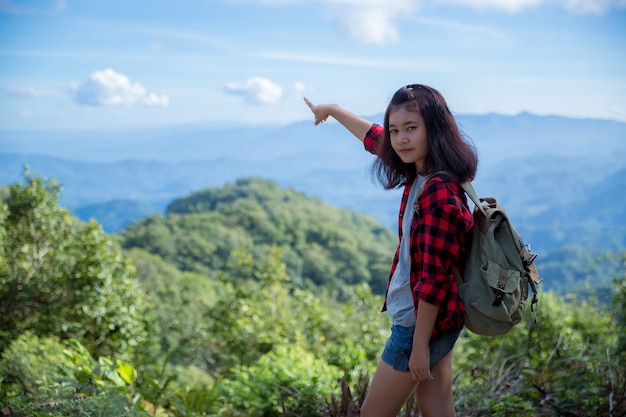 Viaggiatori, giovani donne, guardano le meravigliose montagne e foreste, idee di viaggio per la voglia di viaggiare,