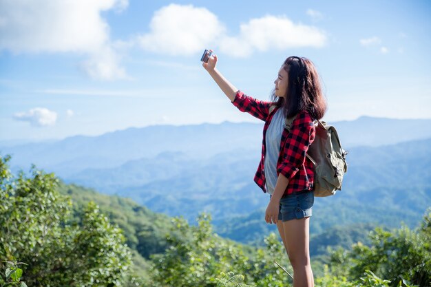 Viaggiatori, giovani donne, guardano le meravigliose montagne e foreste, idee di viaggio per la voglia di viaggiare,