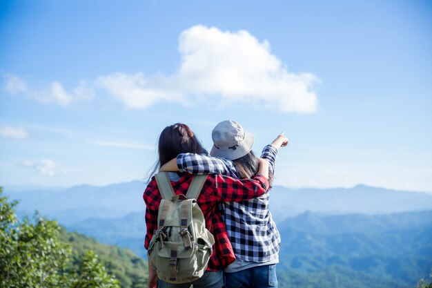 Viaggiatori, giovani donne, guardano le meravigliose montagne e foreste, idee di viaggio per la voglia di viaggiare,