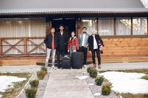 Viaggiatori hipster pronti per un viaggio. Uomini indiani e donne che tengono le valigie a casa.