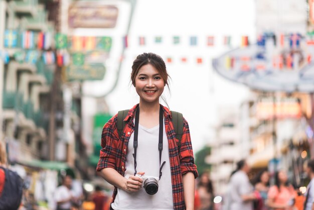 Viaggio asiatico della donna di viaggiatore con zaino e sacco a pelo del viaggiatore in strada di Khao San a Bangkok, Tailandia