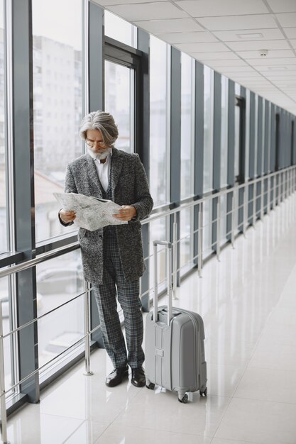 Viaggio di lavoro. Concetto aziendale e di persone. Maschio con mantello grigio. Anziano con una mappa.