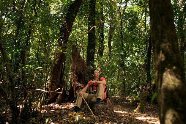 Viandante che si siede nella foresta selvaggia