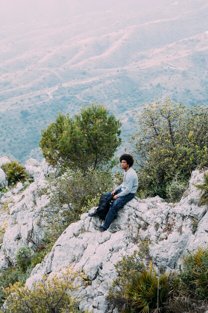 Viandante che si siede sulla roccia