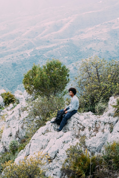 Viandante che si siede sulla roccia