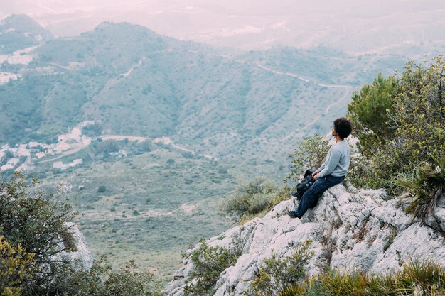 Viandante che si siede sulla roccia