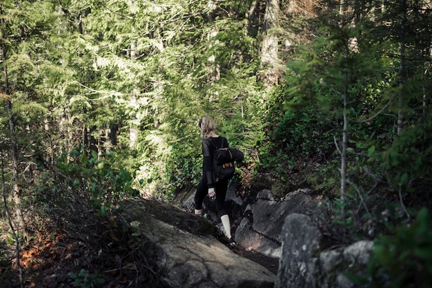 Viandante femminile che cammina facendo un&#39;escursione nella foresta
