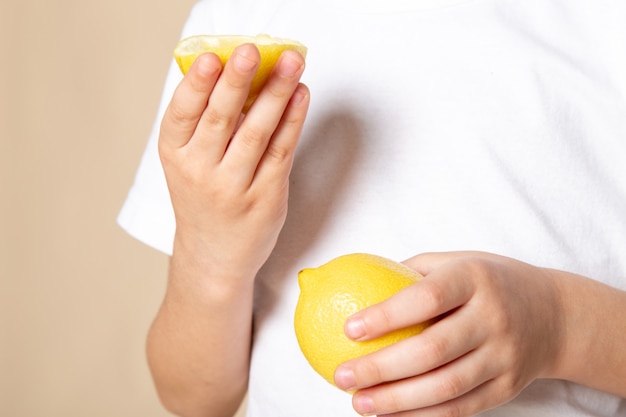 vicino, vista ragazzo che tiene la fetta di limone