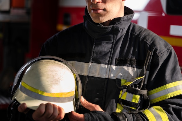 Vigile del fuoco maschio alla stazione con tuta e casco di sicurezza