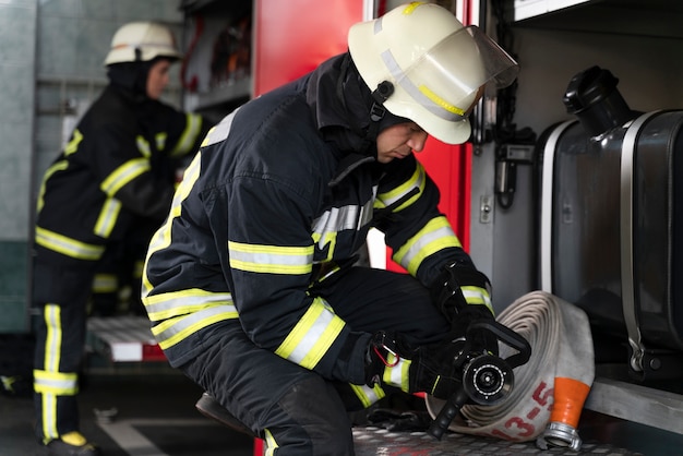 Vigili del fuoco maschi e femmine che lavorano insieme in tute e caschi