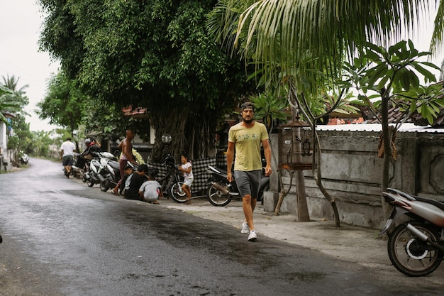 Villaggio balinese, i bambini si nascondono dalla pioggia in un gazebo sotto un baldacchino.