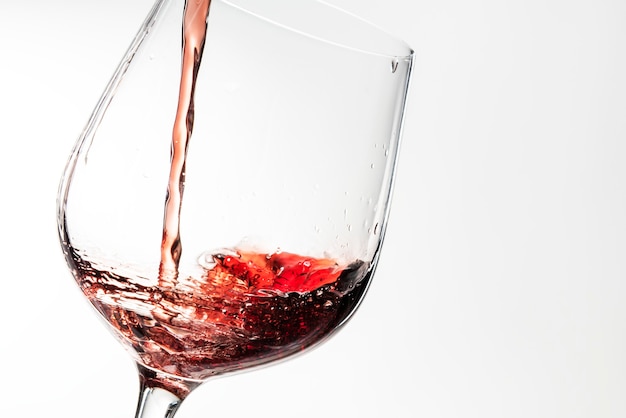 Vino rosso che versa in un bicchiere di vino