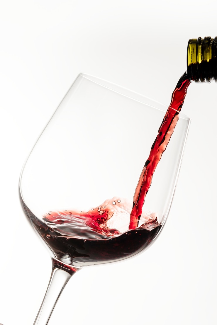 Foto gratuito vino rosso che versa in un bicchiere di vino