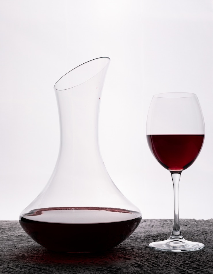 Foto gratuito vino rosso di vista laterale con vetro sul verticale bianco