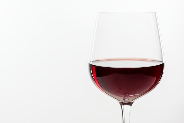 Vino rosso in un bicchiere su sfondo bianco