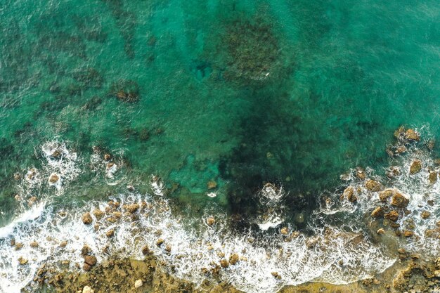 Vista aerea del mare che incontra riva rocciosa