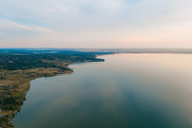 Vista aerea del pittoresco paesaggio di terra, alberi, cielo riflessa nell'acqua.