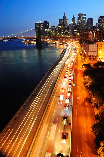 Vista aerea dell'orizzonte del centro di Manhattan di New York City al crepuscolo con i grattacieli illuminati sopra l'East River con le riflessioni.