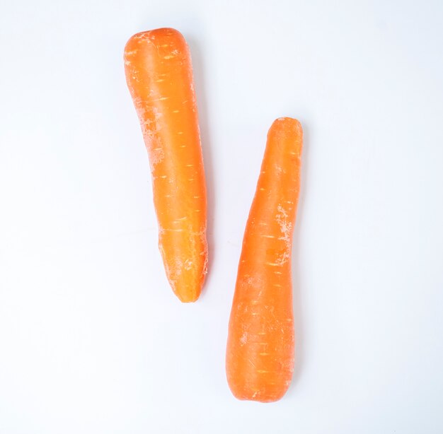 Vista aerea delle carote organiche fresche con priorità bassa bianca