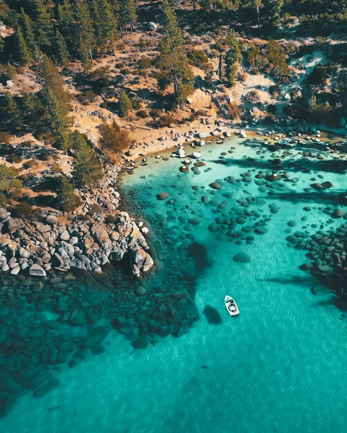 Vista aerea di una barca sull'acqua presso la spiaggia rocciosa