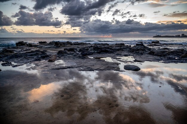 Vista affascinante del tramonto sulla spiaggia rocciosa a Kap Geinitzort a Rostock, Germany