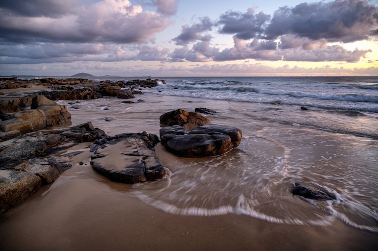 Foto gratuito vista affascinante del tramonto sulla spiaggia rocciosa a kap geinitzort a rostock, germany